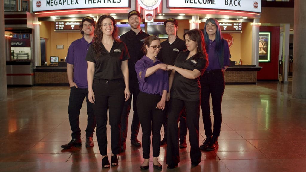 Megaplex employees in front of marquee